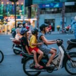 man in yellow shirt riding motorcycle with woman in yellow shirt